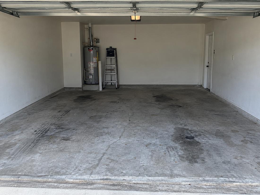 Two-car garage with a stained bare concrete floor